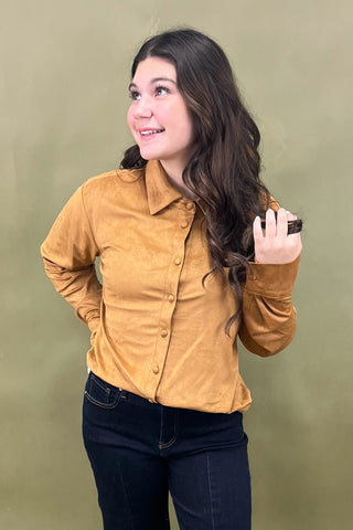 Woman wearing a mustard yellow shirt against a green background