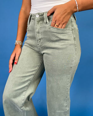 Light sage green wide leg jeans with a high-rise waist and relaxed fit, shown on model.