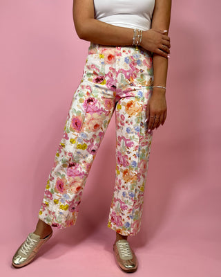 Person wearing floral pants on a pink background