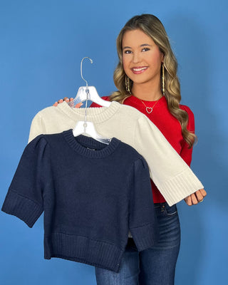 Red ribbed knit top with a crew neckline, puff sleeves, wide ribbed cuffs, and a fitted silhouette.