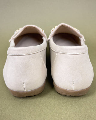 Pair of beige shoes on a green background