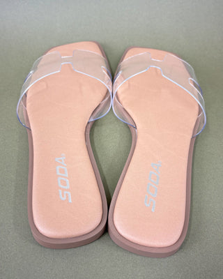 Pair of clear slide sandals green background