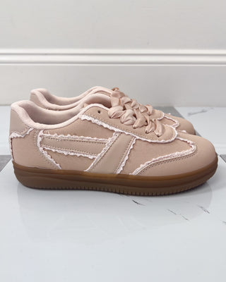 Pair of pink sneakers with white accents on a light gray surface.