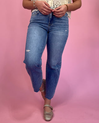 Person wearing blue jeans on a pink background
