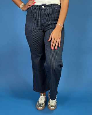 Dark wash pinstripe straight leg jeans with front patch pockets and a high-rise waist, shown on model.