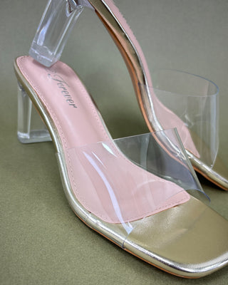 Pink high-heeled shoes with clear transparent soles on a green background