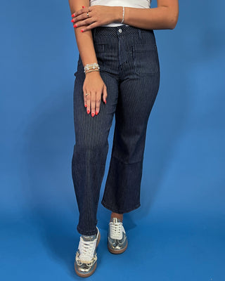 Dark wash pinstripe straight leg jeans with front patch pockets and a high-rise waist, shown on model.