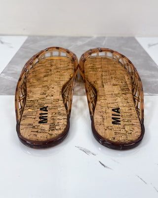 Pair of brown sandals with cork sole on a white surface