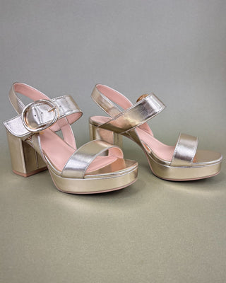 Pair of silver high-heeled sandals with pink straps on a gray background