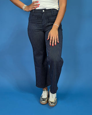 Dark wash pinstripe straight leg jeans with front patch pockets and a high-rise waist, shown on model.