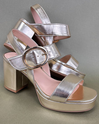 gold and beige high-heeled sandals on a olive background