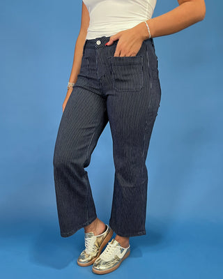 Dark wash pinstripe straight leg jeans with front patch pockets and a high-rise waist, shown on model.