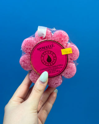 Spongellé Flower Body Wash Infused Buffer available in multiple fragrances, featuring a flower-shaped cleansing sponge infused with body wash and a convenient hanging ribbon.