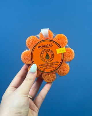 Spongellé Flower Body Wash Infused Buffer available in multiple fragrances, featuring a flower-shaped cleansing sponge infused with body wash and a convenient hanging ribbon.