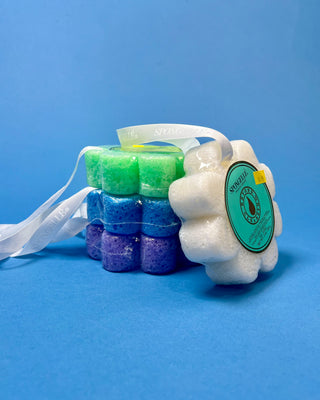 Spongellé Flower Body Wash Infused Buffer available in multiple fragrances, featuring a flower-shaped cleansing sponge infused with body wash and a convenient hanging ribbon.