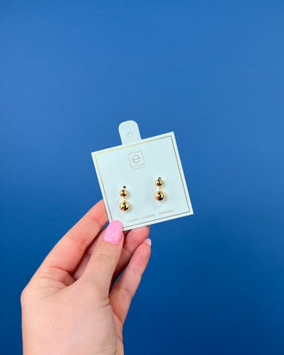 eNewton Classic 8mm Ball Drop Stud Earrings in classic gold featuring polished gold ball studs with suspended 8mm gold ball drops and secure post backs displayed on an eNewton jewelry card.
