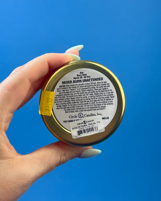 Bird of Paradise tropical scented candle in a brushed gold travel tin with a berry-colored lid, featuring a clean-burning single wick and available in multiple sizes for home fragrance.