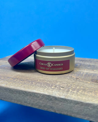 Bird of Paradise tropical scented candle in a brushed gold travel tin with a berry-colored lid, featuring a clean-burning single wick and available in multiple sizes for home fragrance.