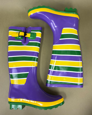 Purple rain boot with green and yellow stripes on a beige background