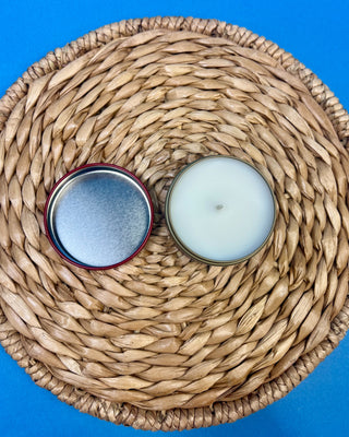 Bird of Paradise tropical scented candle in a brushed gold travel tin with a berry-colored lid, featuring a clean-burning single wick and available in multiple sizes for home fragrance.