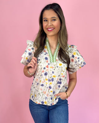 Woman wearing a floral blouse with a pink background