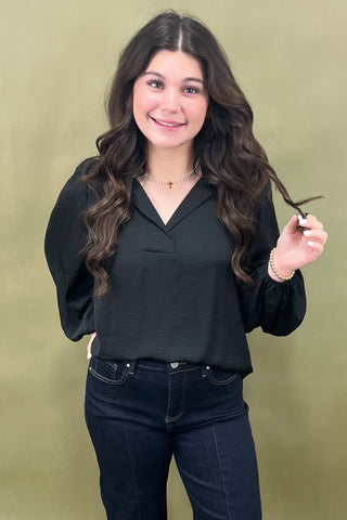Woman holding a section of her hair against a green background