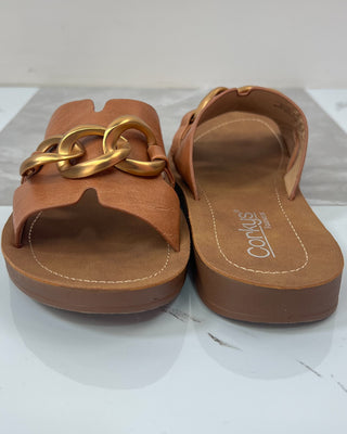 Brown sandals with gold chain detail on a white background