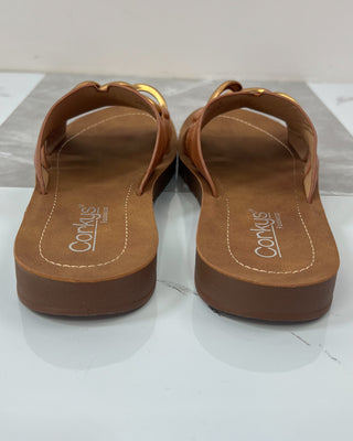 Pair of brown sandals with 'Corkys' branding on a clear background