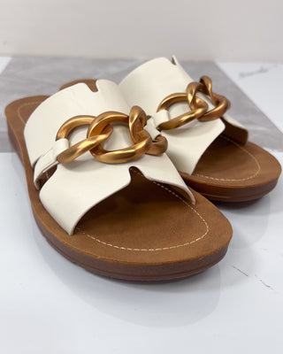 White sandal with gold chain design on a white background