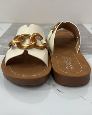Pair of sandals with gold chain design on a white background