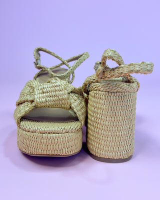 Woven sandals with a bow on a light purple background