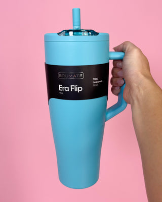 Blue mug with handle and straw on a pink background