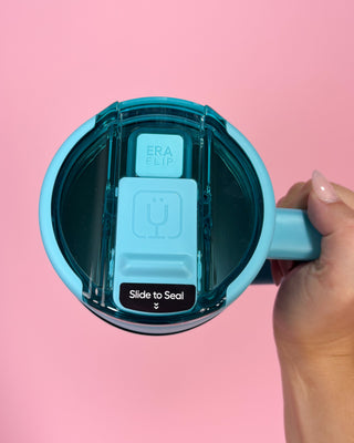 Blue mug with a transparent lid on a pink background