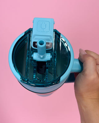 Blue water bottle with a cap on a pink background