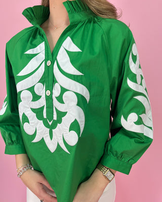Green blouse with white patterns on a pink background