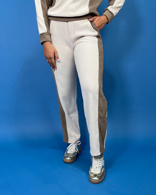 Ivory and taupe color block two-piece pants set with a long sleeve crewneck top and matching straight-leg pants.