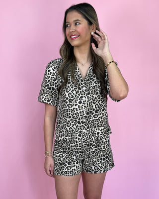 Woman wearing a leopard print outfit against a pink background