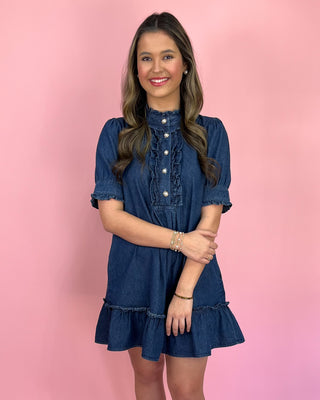 Woman wearing a blue dress against a pink background