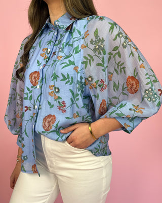 Woman wearing a floral blouse with a pink background