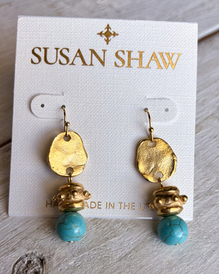 Gold and turquoise earrings on a Susan Shaw branded card.