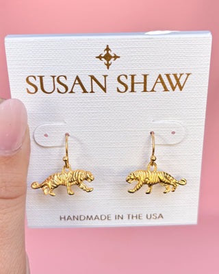 Gold tiger-shaped earrings on a Susan Shaw branded card with a pink background
