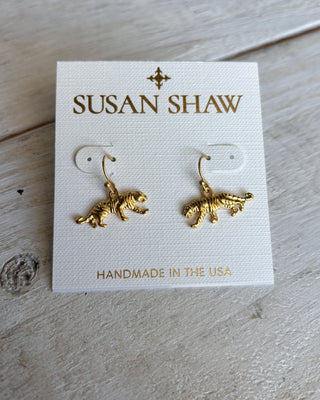 Gold tiger earrings on a Susan Shaw branded card with 'Handmade in the USA' text, on a wooden surface.