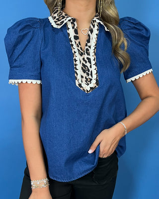 Blue denim puff sleeve top with leopard print collar and neckline trim, white scalloped accents, and a relaxed fit.