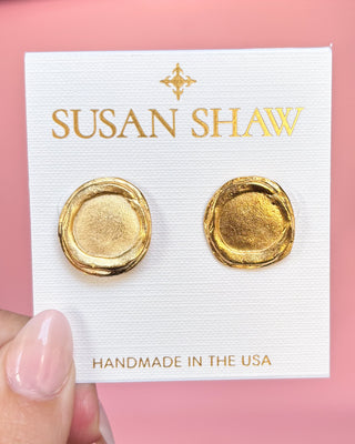 Gold earrings on a Susan Shaw branded card with a pink background