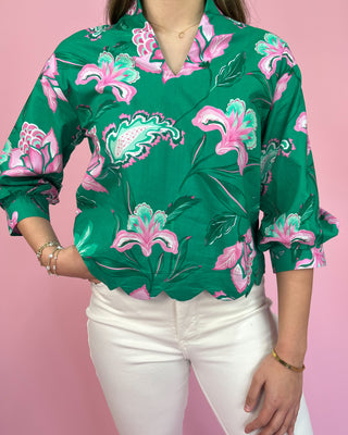 Green floral blouse with pink flowers on a pink background