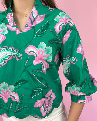 Green floral blouse with pink flowers on a pink background