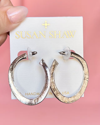 Gold hoop earrings on a Susan Shaw branded card against a pink background