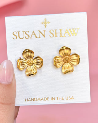 Gold flower earrings on a Susan Shaw branded card with a pink background