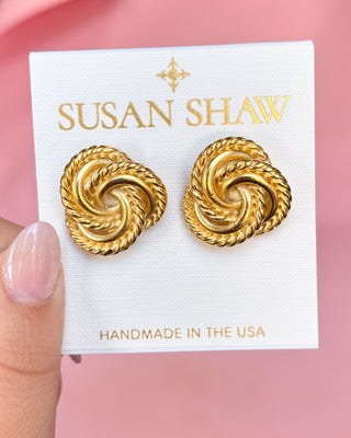 Gold earrings on a Susan Shaw branded card with a pink background
