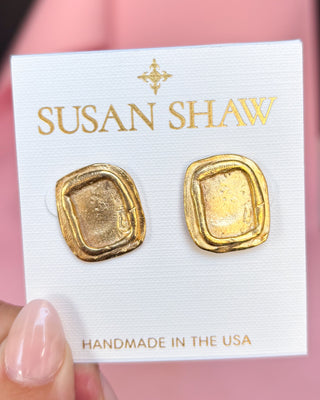 Gold earrings on a Susan Shaw branded card with a pink background